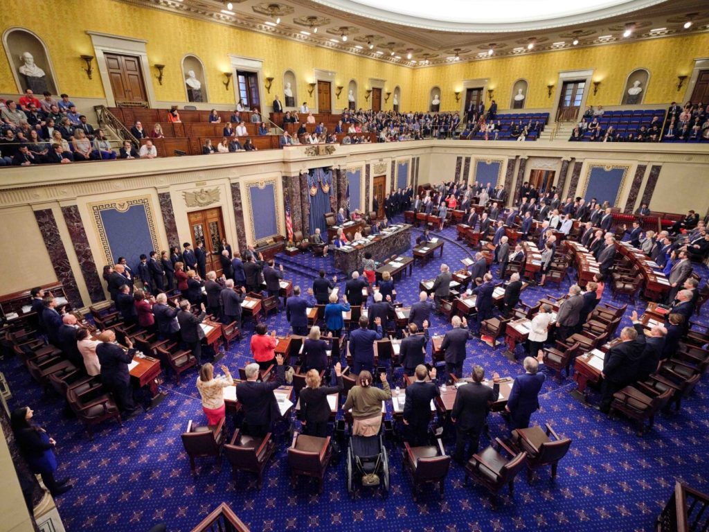 The United States Senators, who have the power to convict a president, all stand and raise their right hands on the Senate floor.