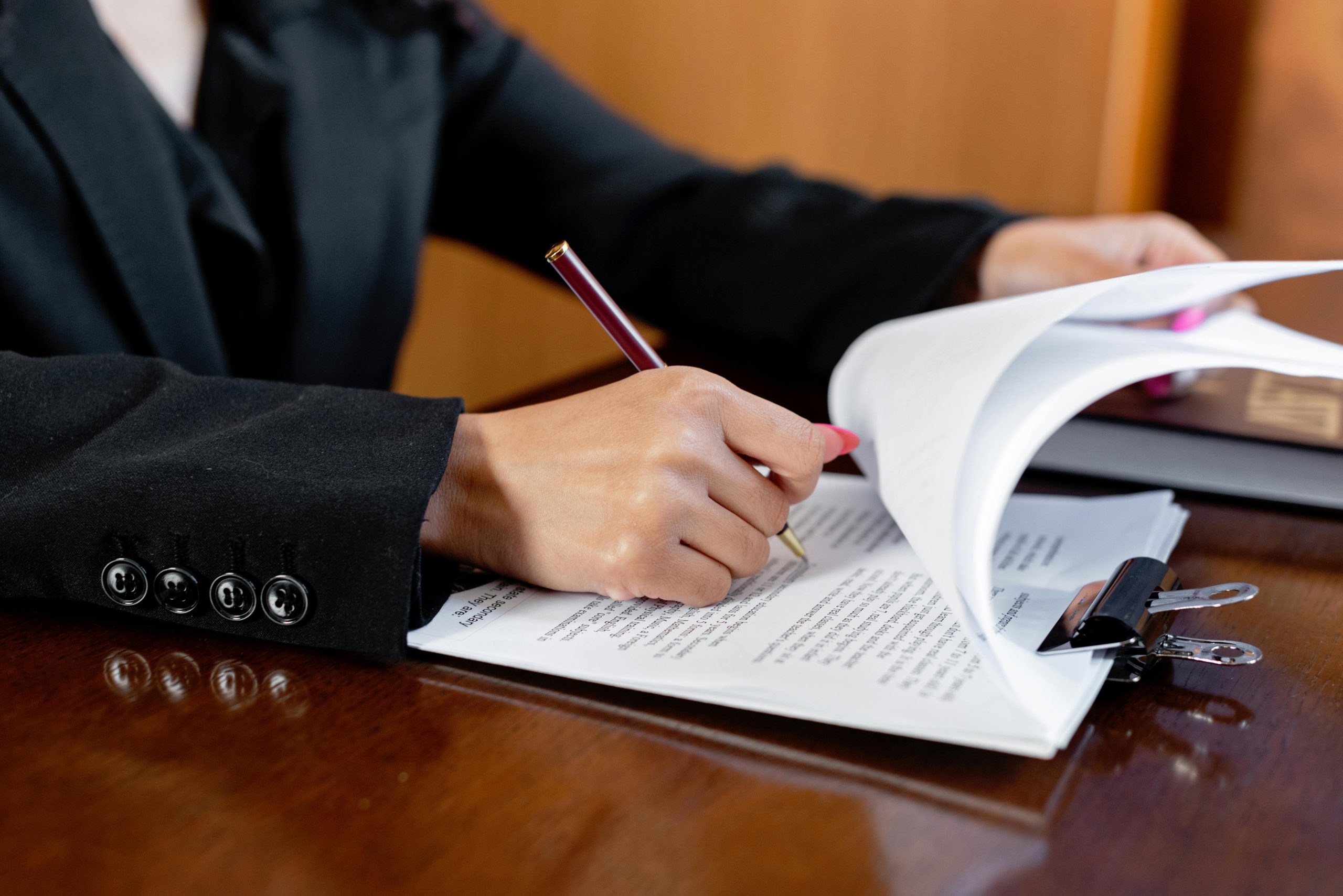 A person at a desk reviews a document on a clipboard.
